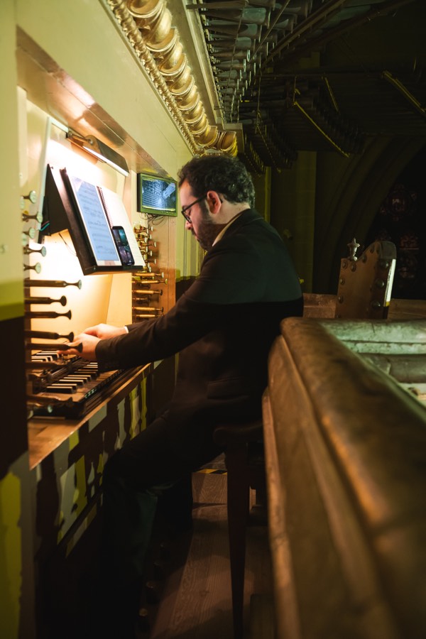 Organista junto a los tubos del órgano