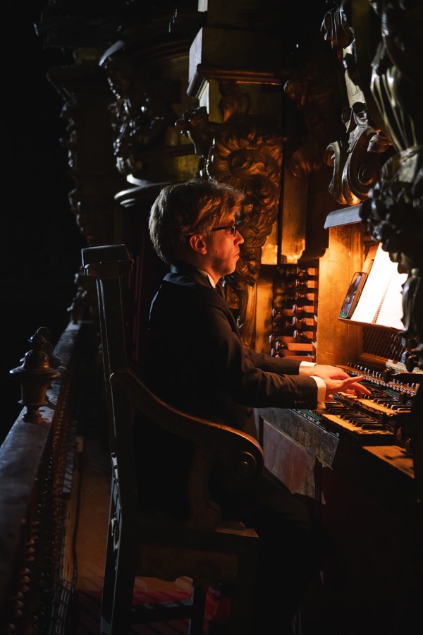 Organista tocando en la consola bajo luz cálida